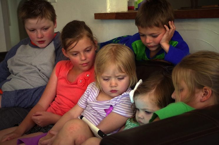 Cousins around an iPad. No idea what they are watching.