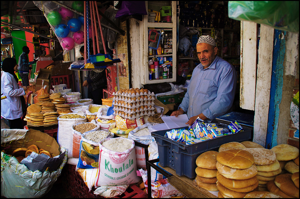 Morocco: A vendor in the Rabat medina selling bread, eggs, flour... and beach balls