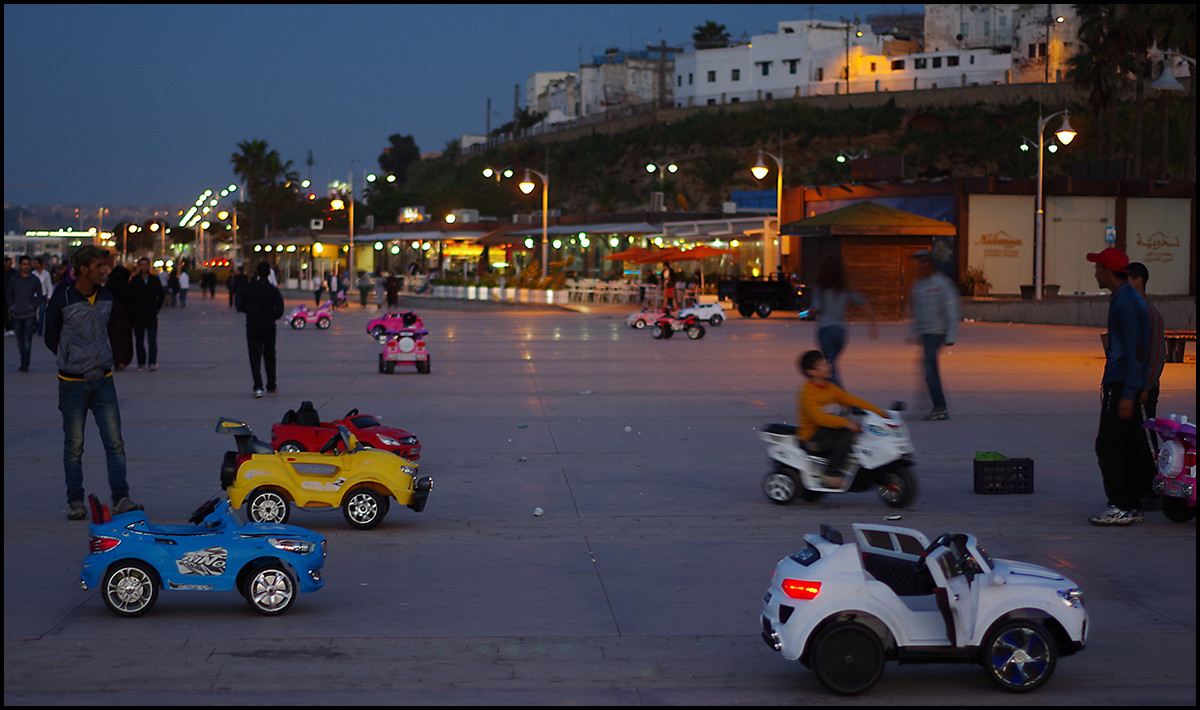 Rabat, Morocco. Kids renting a ride in toy cars on the Rabat boardwalk